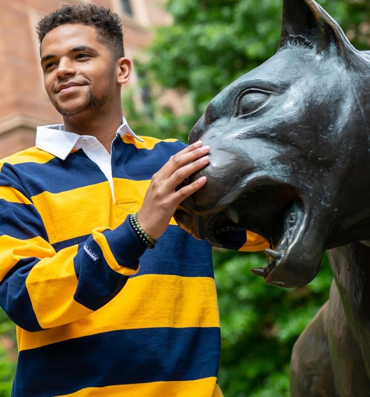 Student posting with Roc statue
