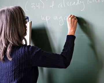 Professor writing on chalkboard